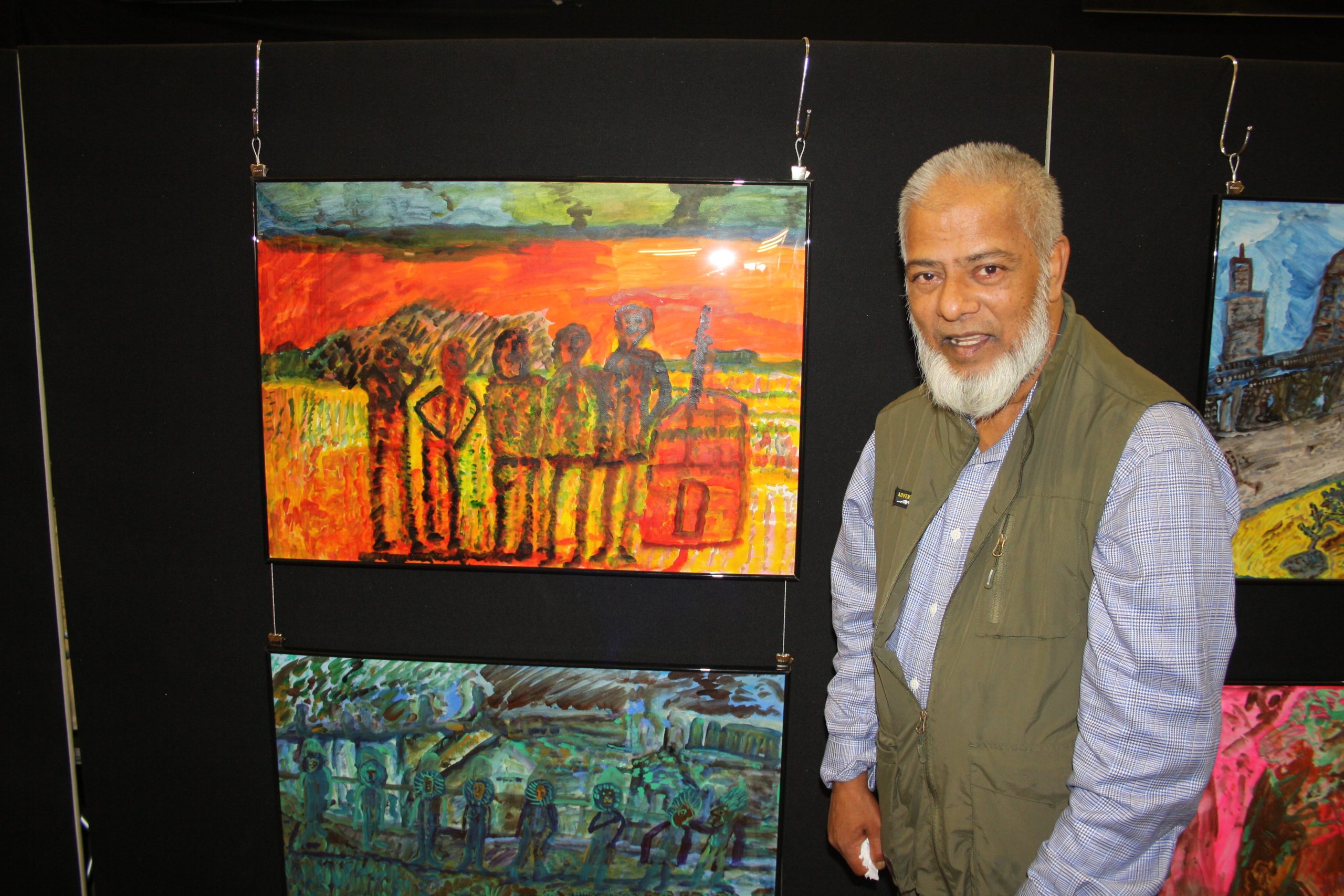 man standing next to painting on easel