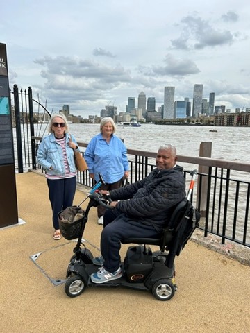 three people near the riverbank backdrop